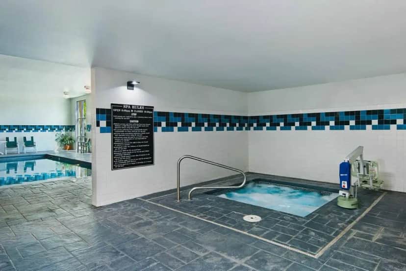 a pool with a hot tub in the middle of a building at Oxford Suites Yakima in Yakima