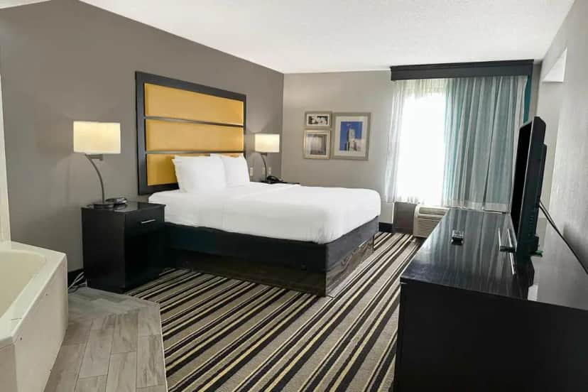 a hotel room with a bed and a television at OYO Townhouse Jackson - Ridgeland in Jackson
