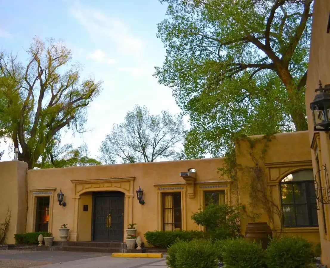 a yellow house with trees in front of it at Palacio de Marquesa in Taos