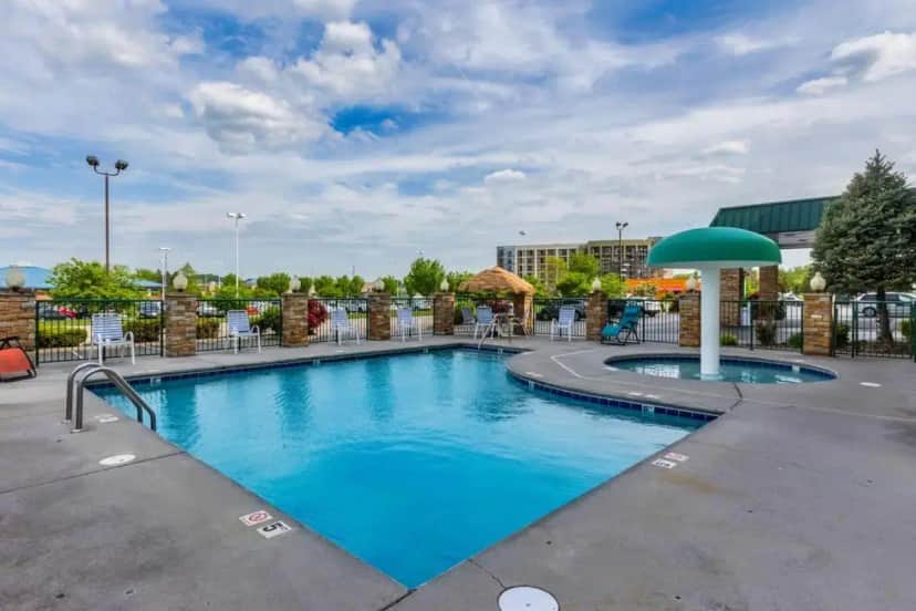 a pool at a resort with chairs and a umbrella at Park Grove Inn in Pigeon Forge