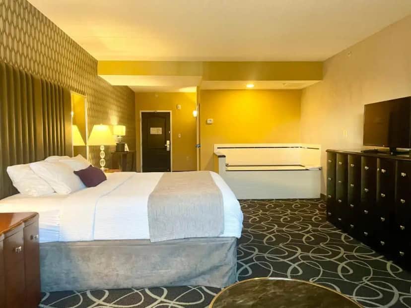 a hotel room with a large bed and a television at Park Manor Hotel in Clifton Park