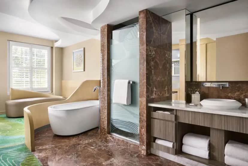 a bathroom with a tub and a sink and a mirror at Pasadena Hotel & Pool in Pasadena