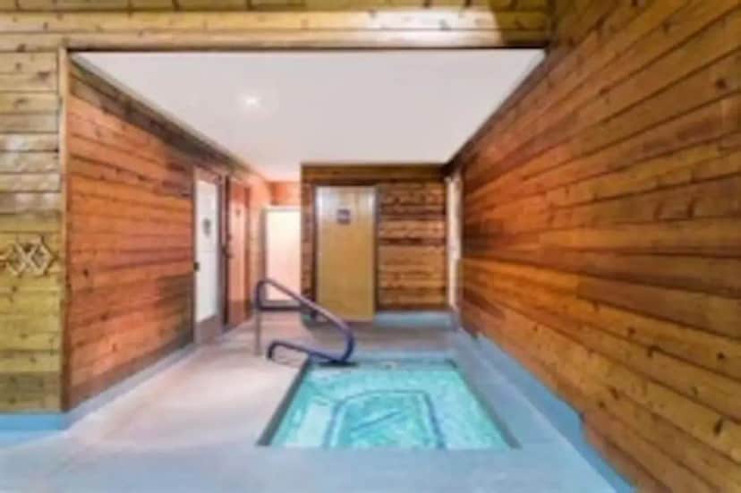 a room with a hot tub in a wooden wall at Pinetop Studio Suites in Pinetop-Lakeside