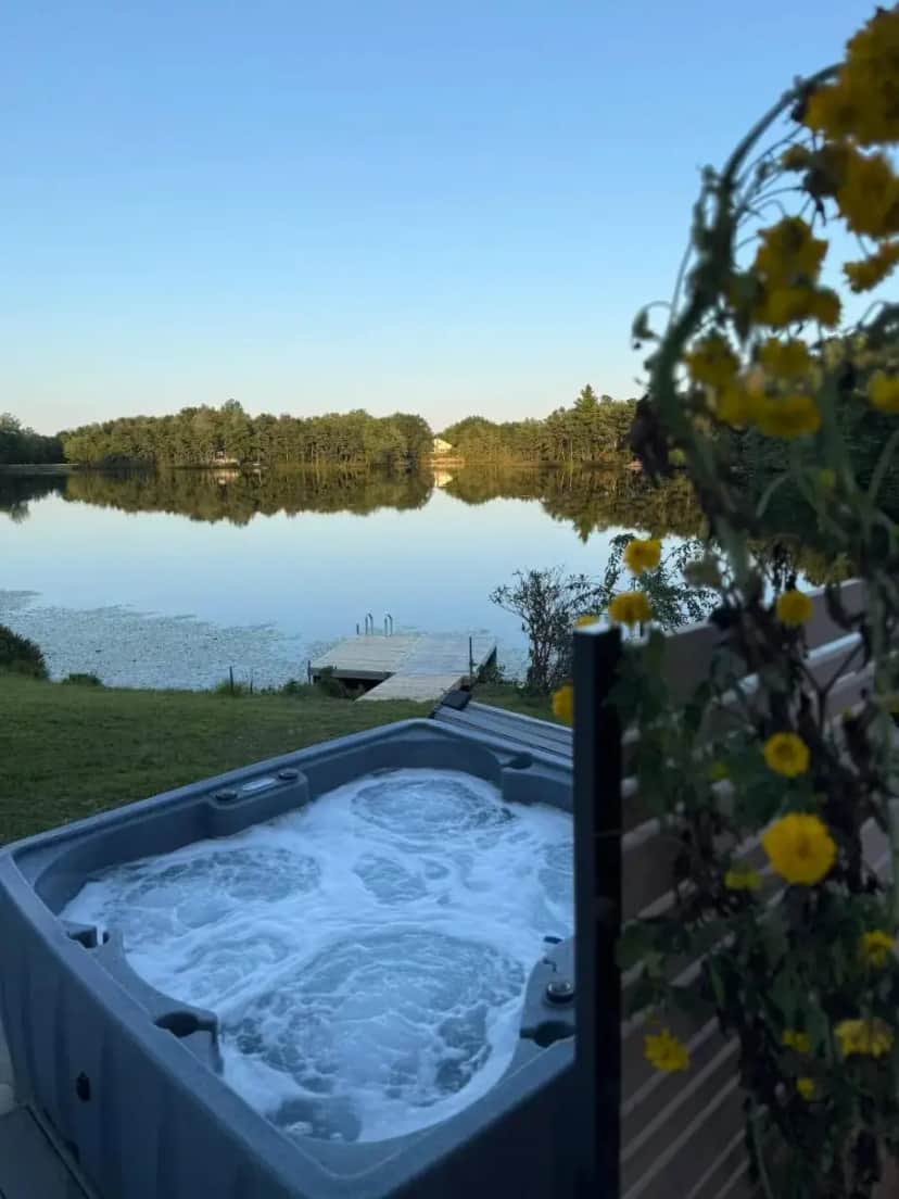 a jacuzzi tub with a view of a lake at Poconos Lakefront Retreat | * Hot Tub * Arcades * in Long Pond