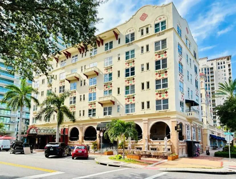 a large building on a city street with palm trees at Ponce De Leon Hotel in St. Petersburg