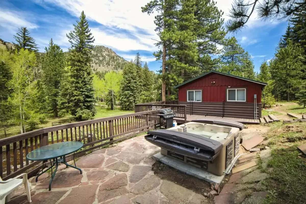 a hot tub on a deck next to a house at Ponderosa Lodge in Estes Park