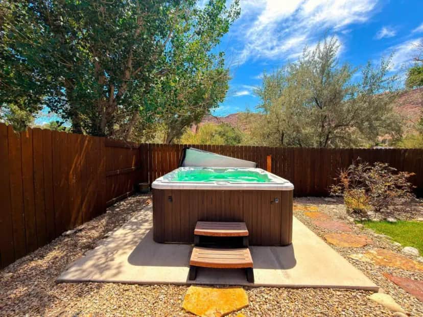 a hot tub in a backyard with a wooden fence at Portal Vista #443 in Moab