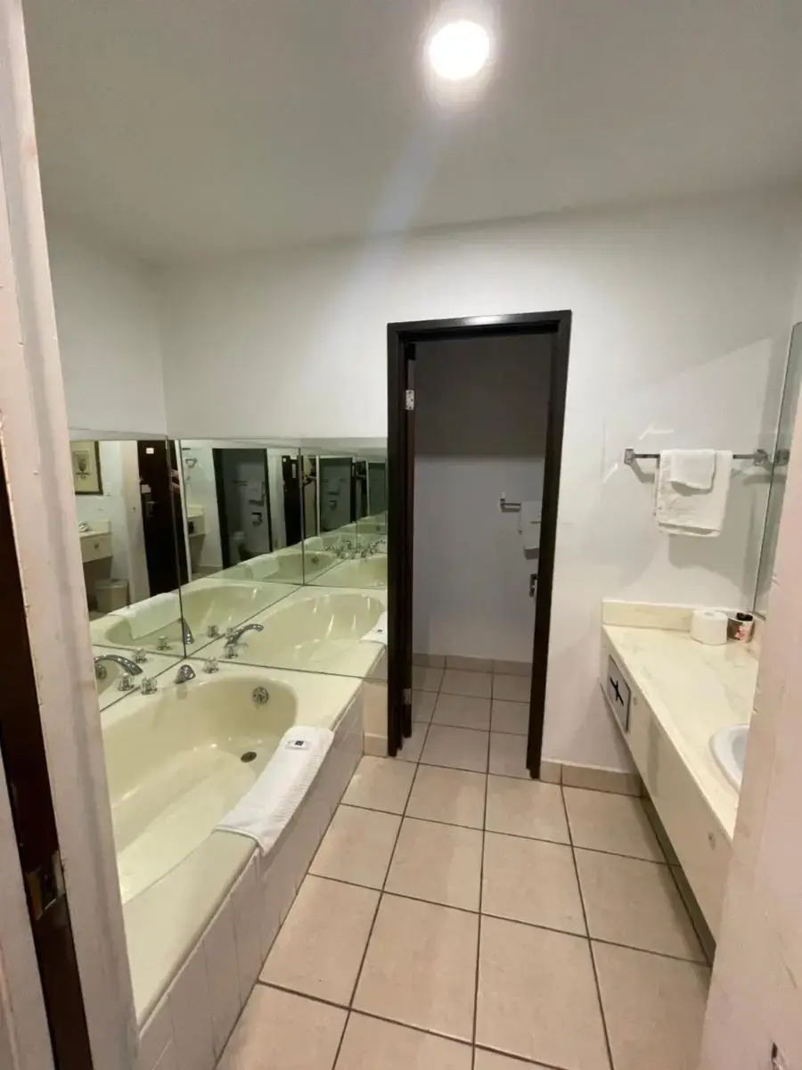 a large bathroom with a tub and a sink at Portside Inn & suites in San Pedro