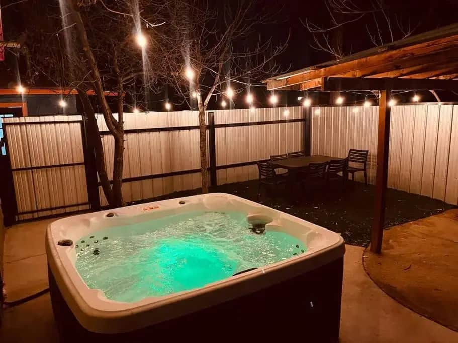 a hot tub in a yard with a table and lights at Prickly Pear at Cactus Flower-Private HOT TUB-Pet Friendly-No Pet Fees! in Albuquerque
