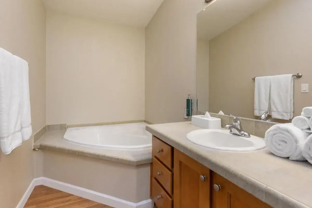 a bathroom with a tub and a sink with towels at PVC at The Roundhouse Resort in Pinetop-Lakeside
