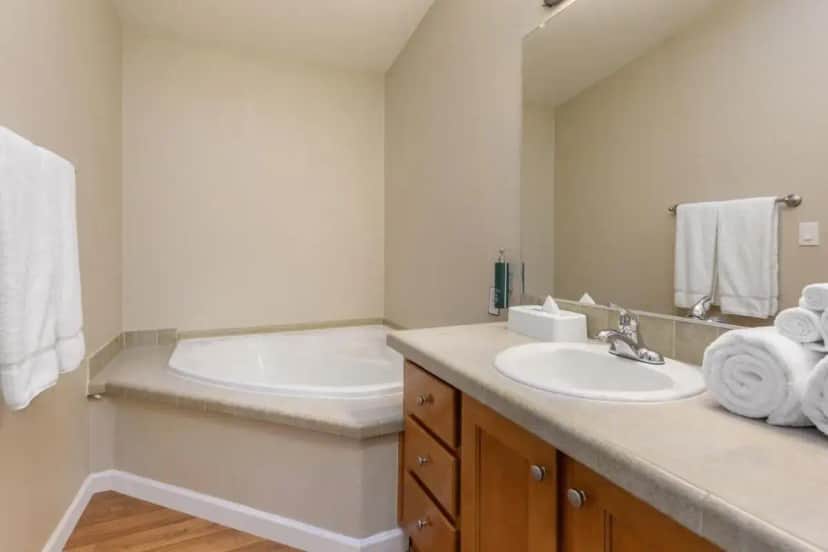 a bathroom with a tub and a sink with towels at PVC at The Roundhouse Resort in Pinetop-Lakeside