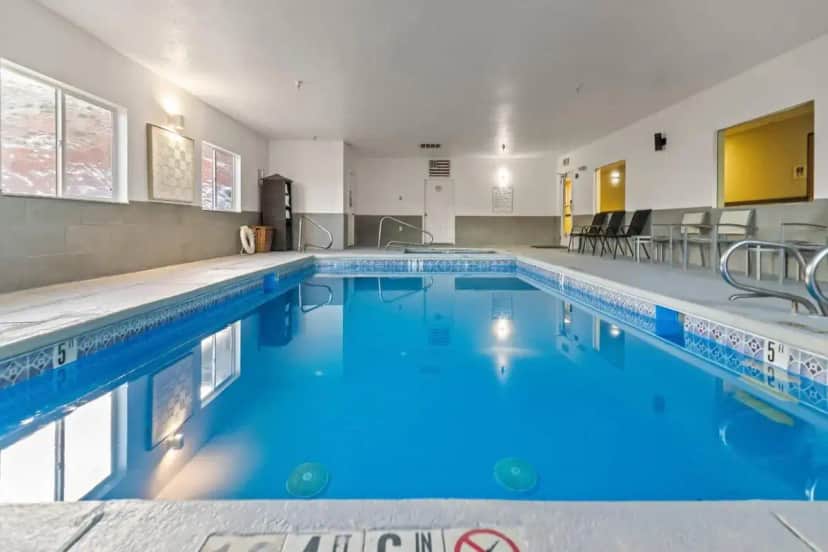 a pool with blue water in a building at Quality Inn & Suites Salina National Forest Area in Salina