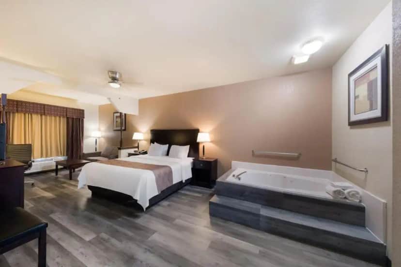a hotel room with a bed and a bath tub at Quality Inn & Suites Terrell in Terrell