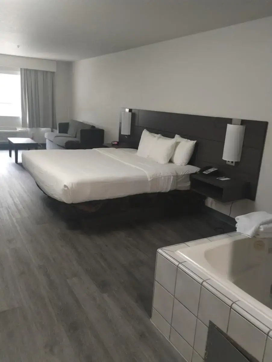 a hotel room with a bed and a bath tub at Quality Inn & Suites Wilsonville in Wilsonville