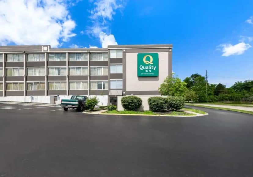 a building with a car parked in front of it at Quality Inn Dayton Airport in Englewood