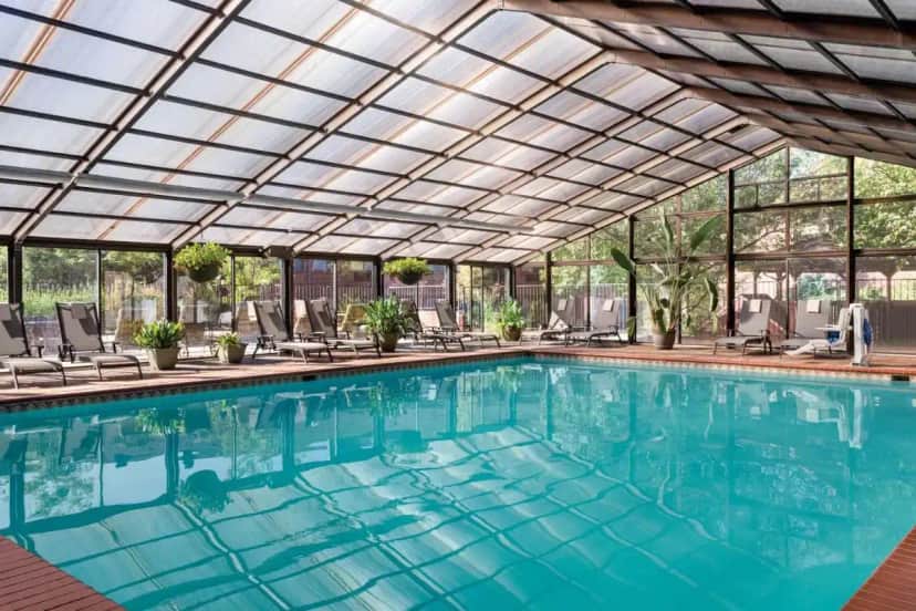 an indoor swimming pool with a glass ceiling at Radisson Hotel Colorado Springs Airport in Colorado Springs