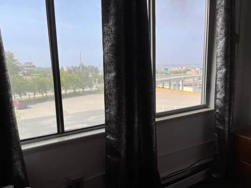 a room with two windows with a view of a street at Ramada Downtown by Wyndham Anchorage in Anchorage