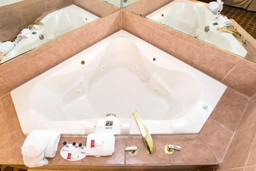 a large bath tub in a bathroom with two sinks at Ramada by Wyndham Plymouth Hotel & Conference Center in Plymouth