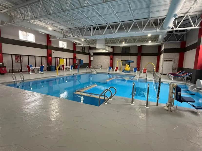 a large swimming pool in a large building at Ramada by Wyndham Waupaca in Waupaca