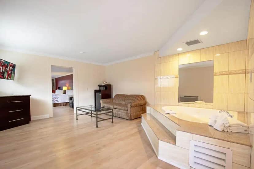 a bathroom with a tub and a living room at Red Roof Inn & Suites Monterey in Monterey