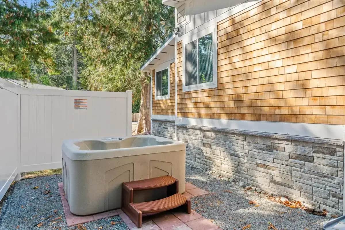 a bath tub sitting outside of a house at Relajate y recargate de buena vibra en nuestras cabanas de Camano Island in Camano