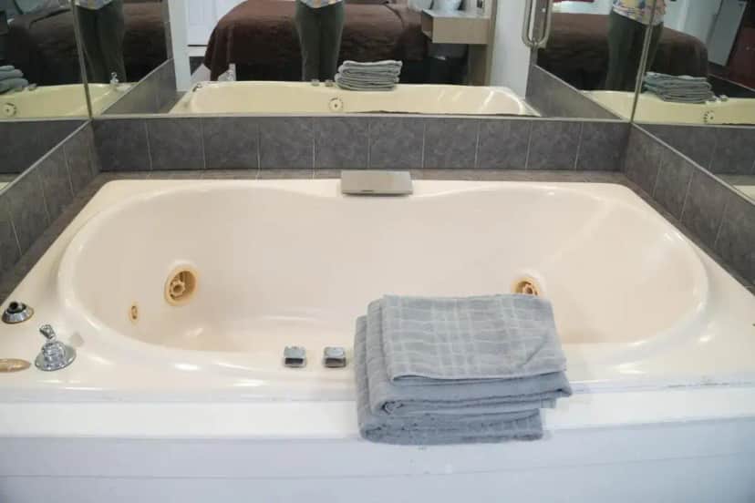 a white bath tub with a towel in it at Relax Inn in Webster