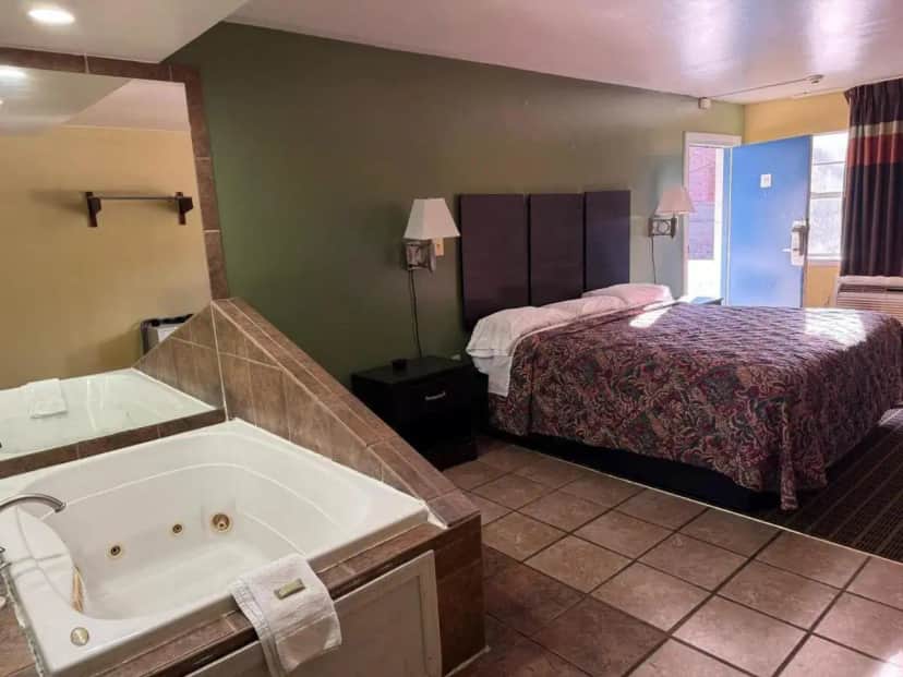 a hotel room with a tub and a bed at Relax Inn in Hampton