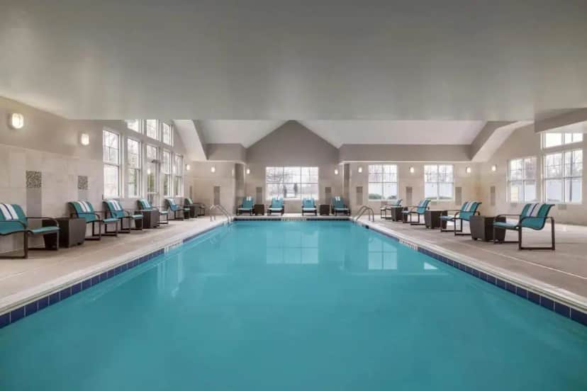 a large swimming pool with blue water in a building at Residence Inn by Marriott Albany Washington Avenue in Albany