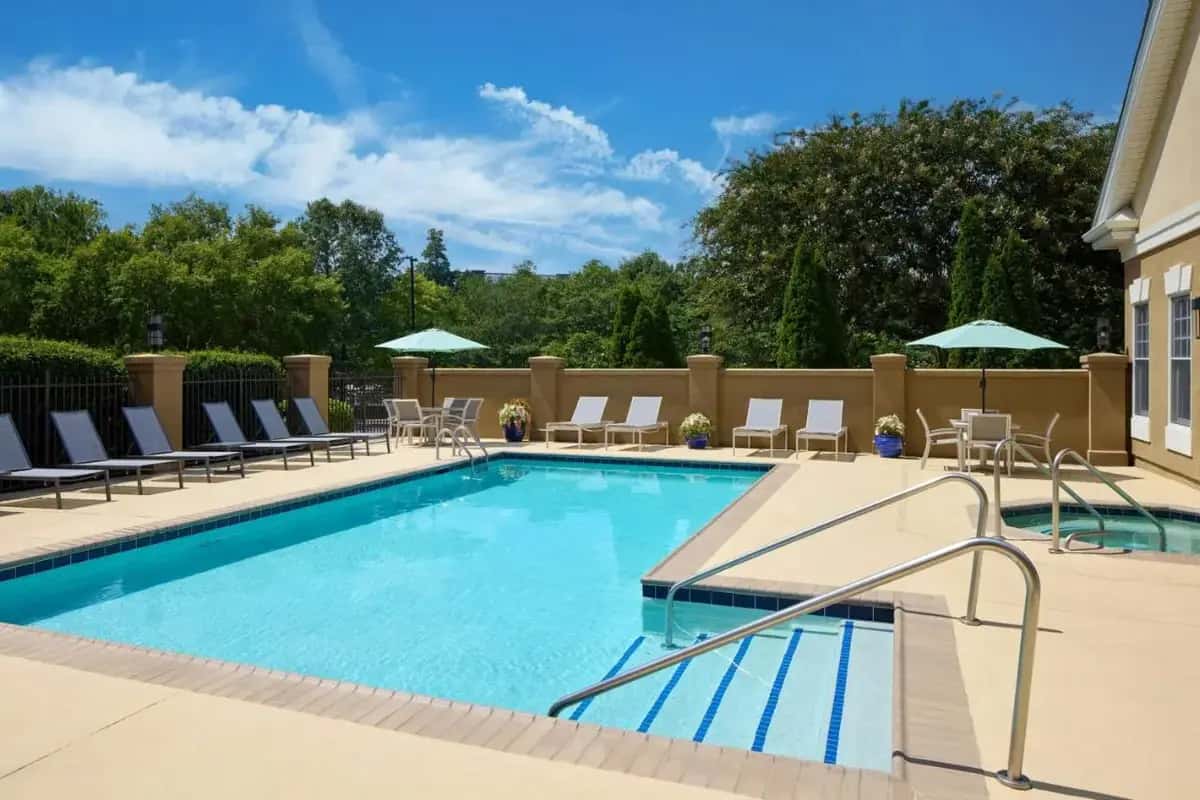 a large swimming pool with chairs and umbrellas at Residence Inn by Marriott Raleigh Crabtree Valley in Raleigh