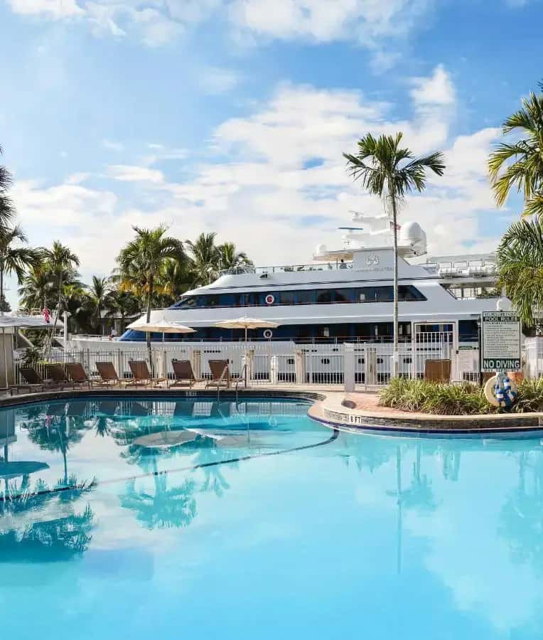 a cruise ship is docked next to a large swimming pool at Riverside Hotel in Fort Lauderdale
