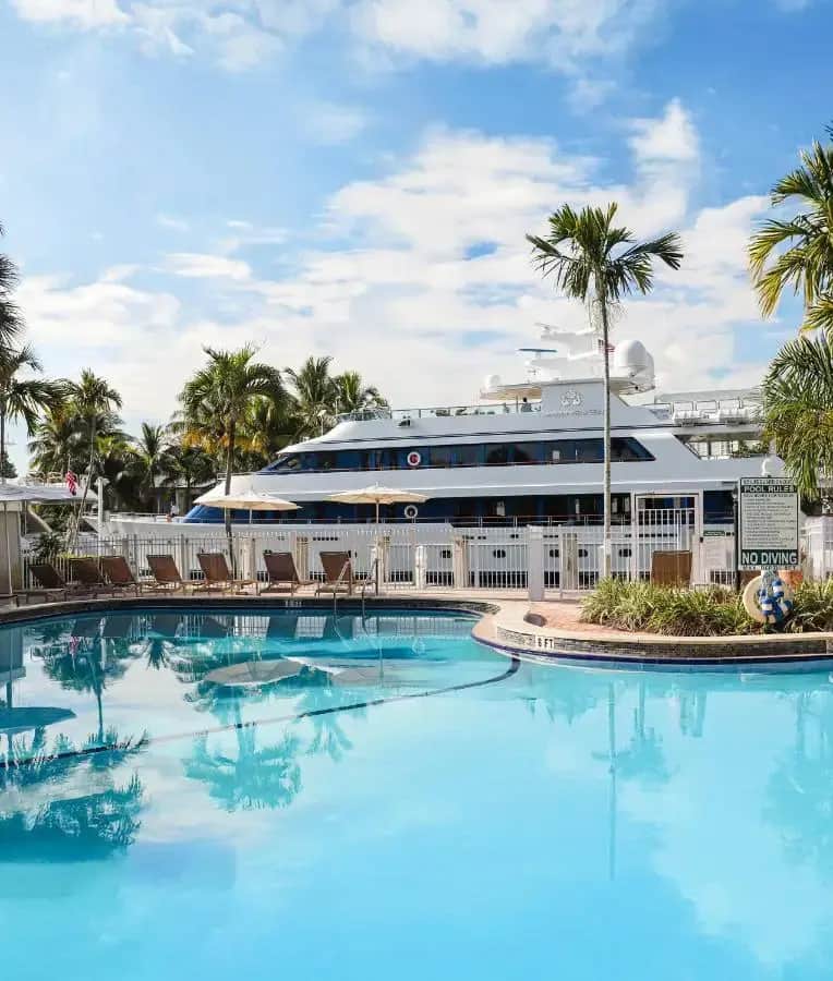 a cruise ship is docked next to a large swimming pool at Riverside Hotel in Fort Lauderdale