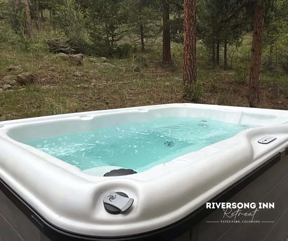 a jacuzzi tub in the middle of a forest at Riversong Inn Retreat in Estes Park