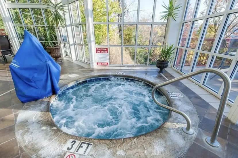 a large hot tub in a room with windows at Luxury 2 Bedroom 2 Bath Condo at Riverstone Resort and Spa in Pigeon Forge
