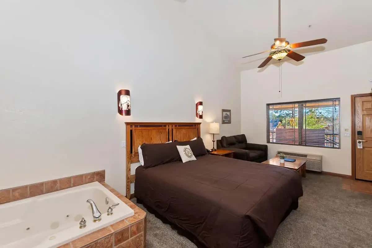 a bedroom with a bed and a bath tub at Robinhood Resort in Big Bear Lake