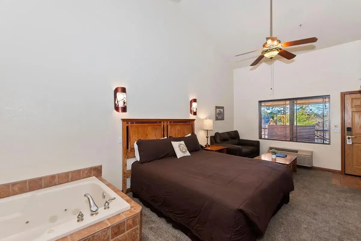 a bedroom with a bed and a bath tub at Robinhood Resort in Big Bear Lake