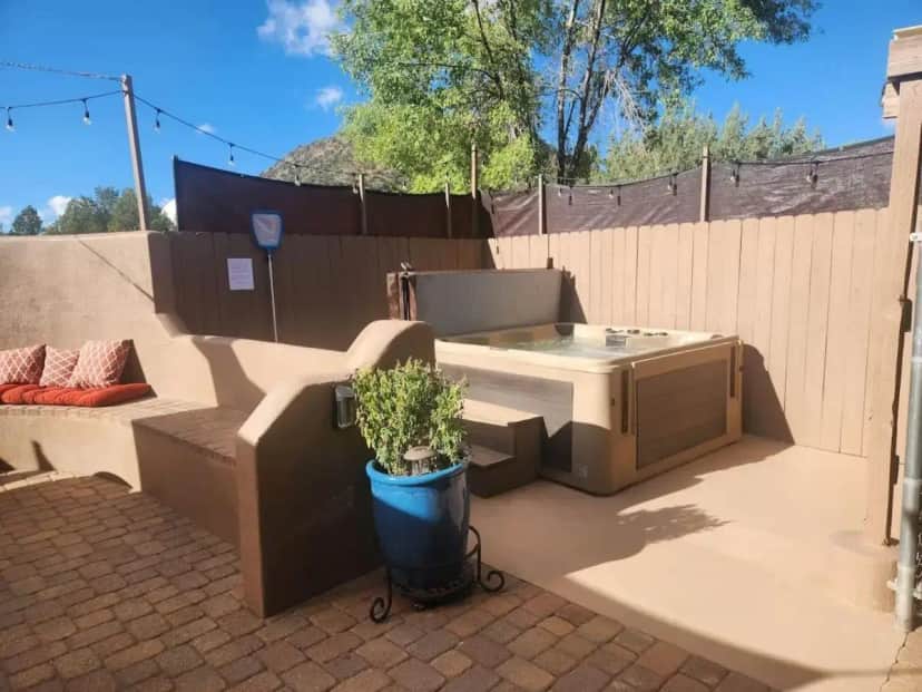 a patio with a hot tub and a potted plant at Robins Red Rock Getaway Suite B in Oak Creek