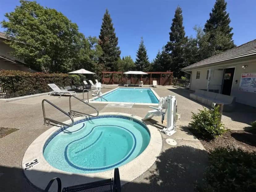 a swimming pool with a hot tub in a yard at Rocklin Park Hotel, Trademark Collection by Wyndham in Rocklin