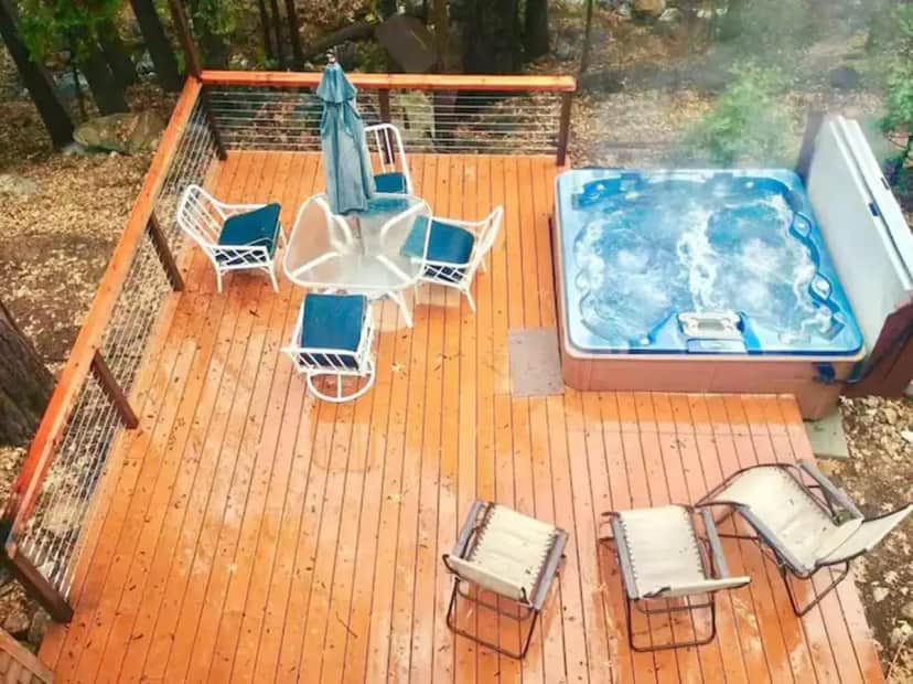 a deck with a pool and chairs and an umbrella at Root-Stone Lodge in Fern Valley