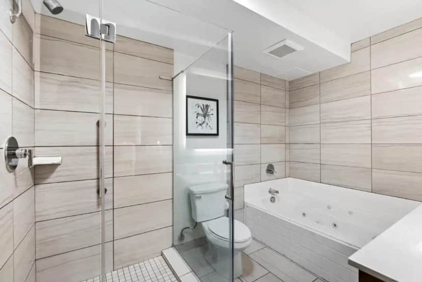 a bathroom with a tub and a toilet and a sink at Royal Palace Westwood Hotel in Los Angeles