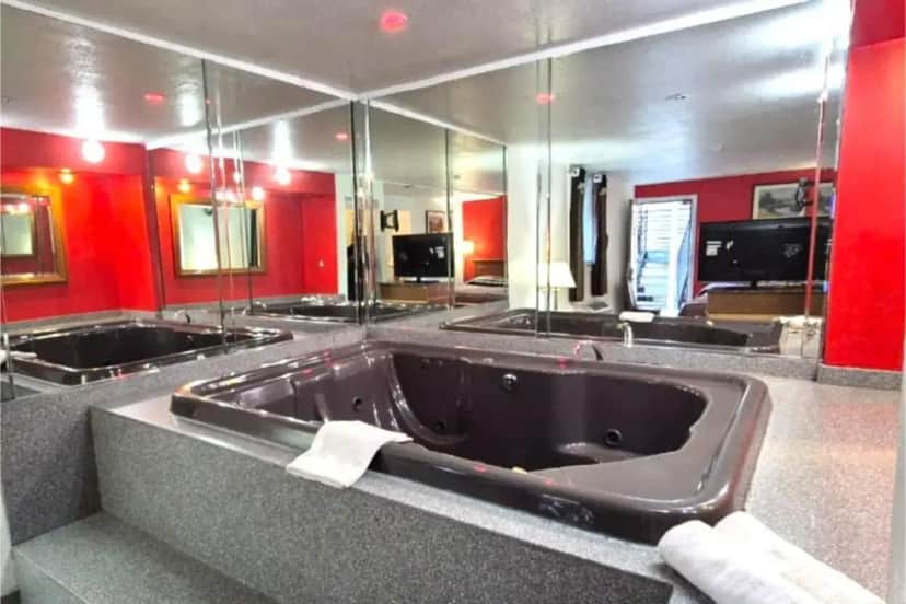 a large bathroom with a large tub with mirrors at Saratoga Motel By Capital O Near Midway Airport Chicago IL in Burbank