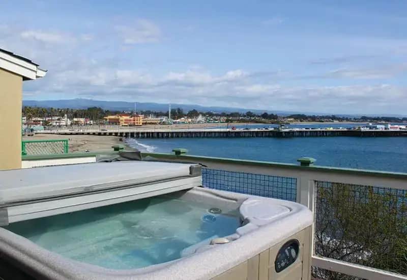 a hot tub on a balcony next to the water at Sea & Sand Inn in Santa Cruz