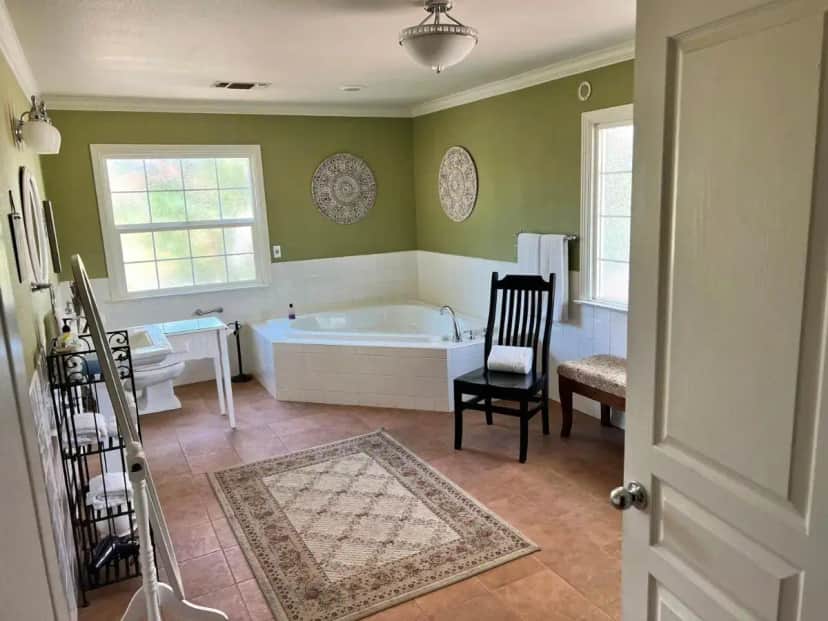 a bathroom with a bath tub and a chair at Sequoia View Vineyard in Sanger