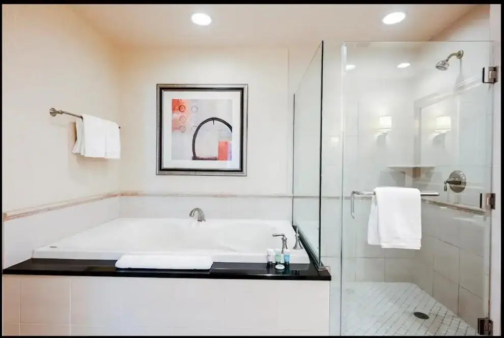 a white bathroom with a tub and a shower at Signature MGM Suite with Strip and Sphere View in Las Vegas