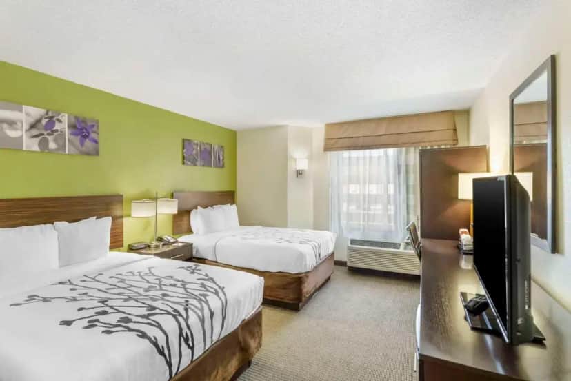 a hotel room with two beds and a flat screen tv at Sleep Inn Hickory South in Hickory