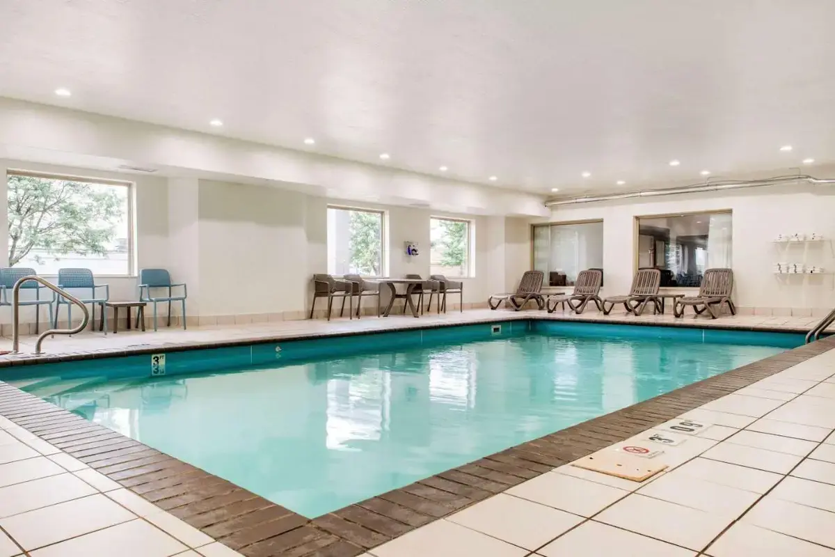 a pool in a hotel with chairs and tables at Sleep Inn & Suites Columbus South in Columbus