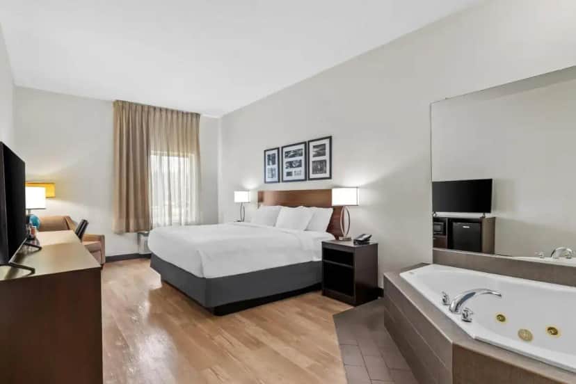 a hotel room with a bed and a bath tub at Sleep Inn & Suites Hiram - Atlanta Northwest in Hiram
