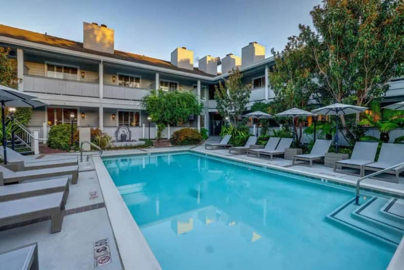 a pool at a hotel with chairs and umbrellas at Sonoma Valley Inn, Tapestry Collection by Hilton in Sonoma