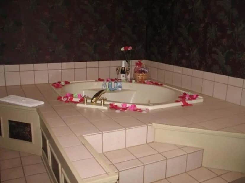 a bathroom with a tub with pink flowers on it at Spruce Hill Inn & Cottages in Mansfield