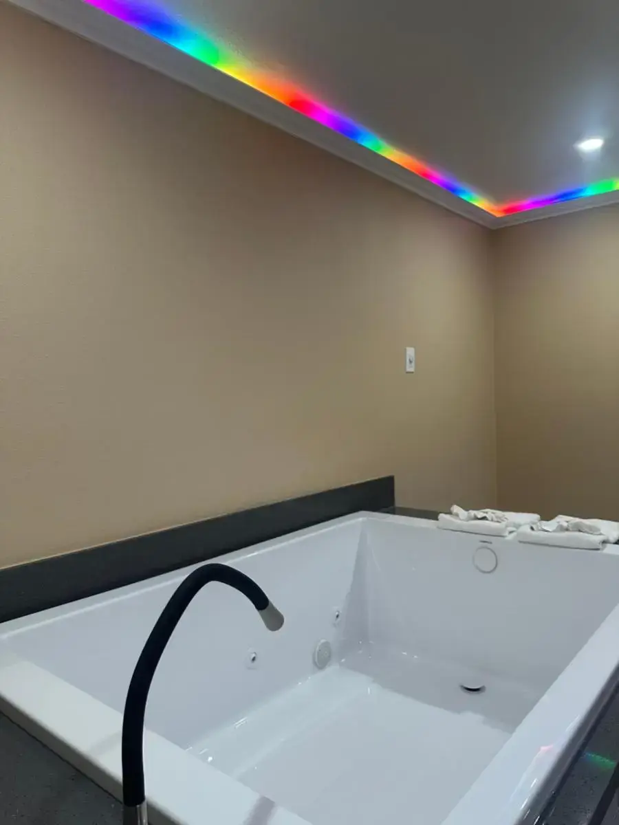 a room with a bathtub with a rainbow light at Stardust inn in Azusa
