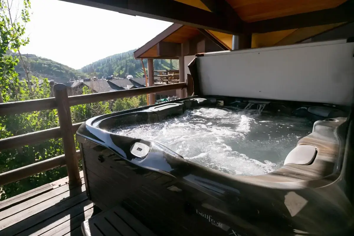 a hot tub on a deck with a view of a mountain at Stein Eriksen Lodge Deer Valley in Park City